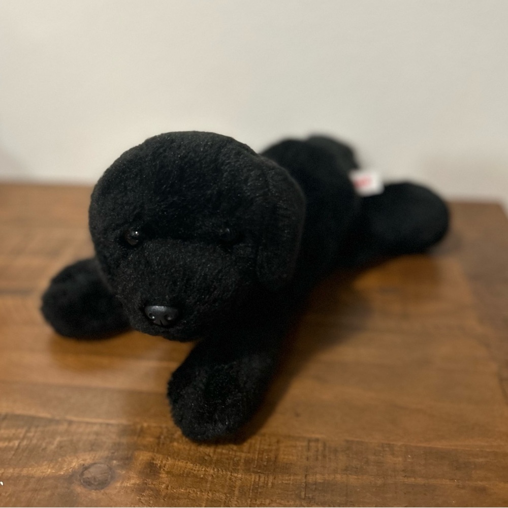 Black Labrador plush in resting position